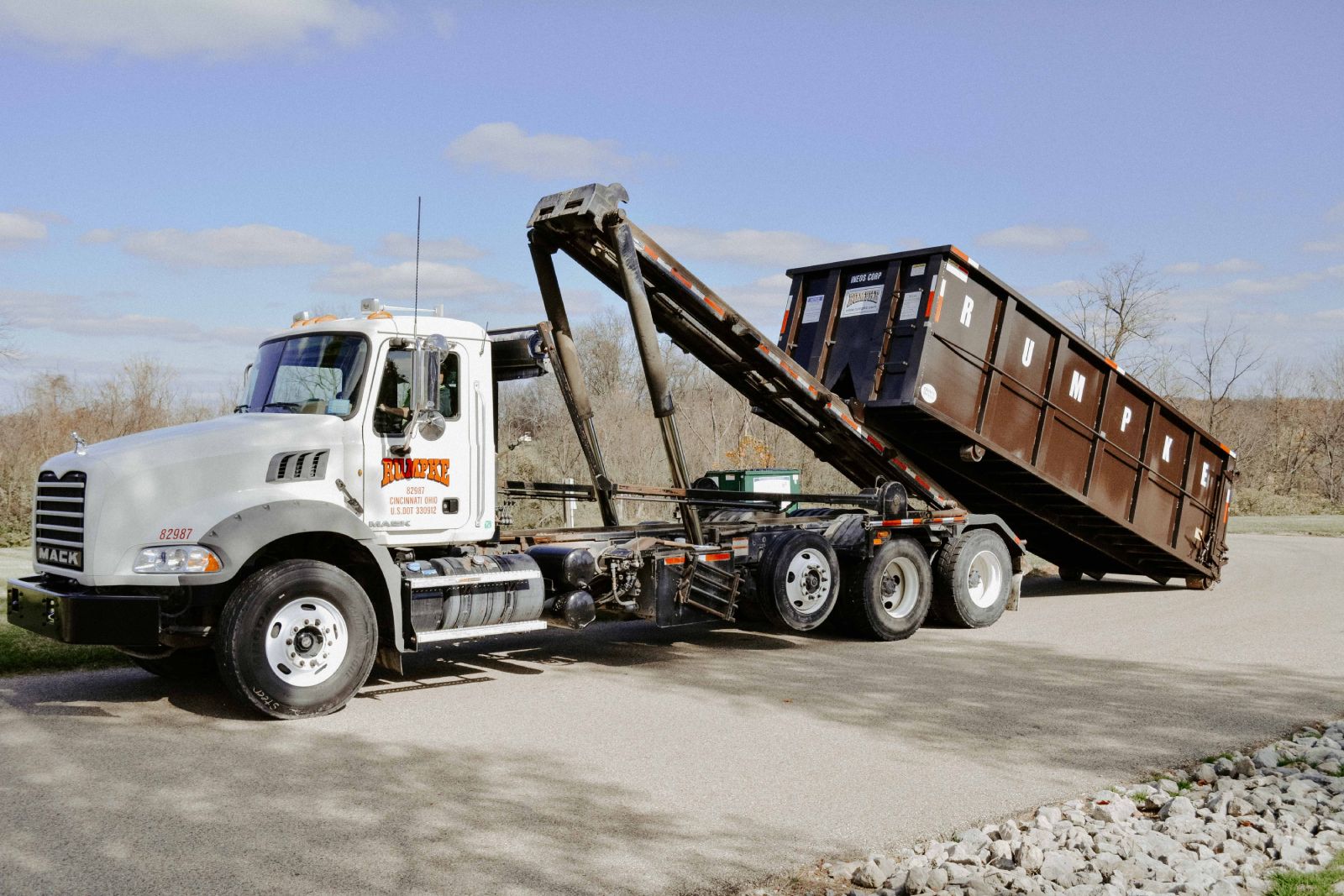 Rumpke Truck Dropping Roll Off Dumpster For Business Waste