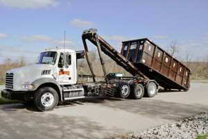 Rumpke Truck Picking Up Roll Off Dumpster For Construction