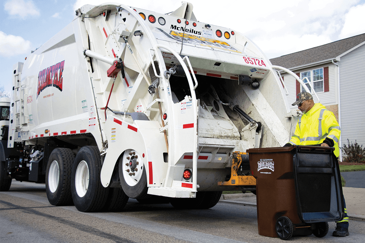 Rumpke Driver Emptying Residential Trash Into Trash Truck