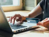 Customer With Credit Card Typing Account Information On Laptop