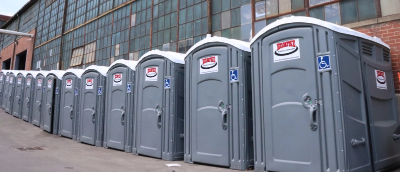 Green Porta Potties In Front Of Building
