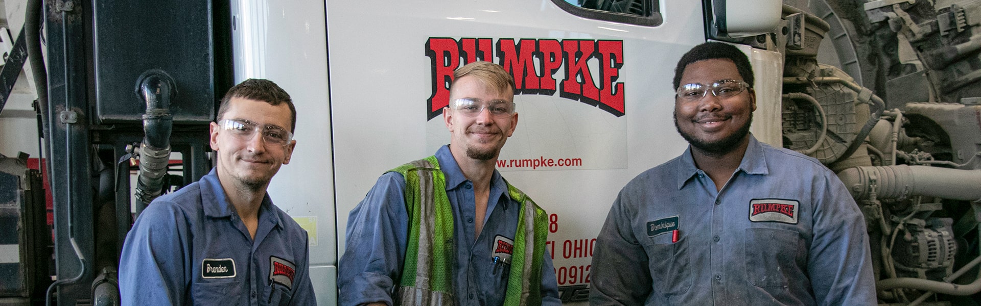 Three Rumpke Employees In Front Of Rumpke Trash Truck